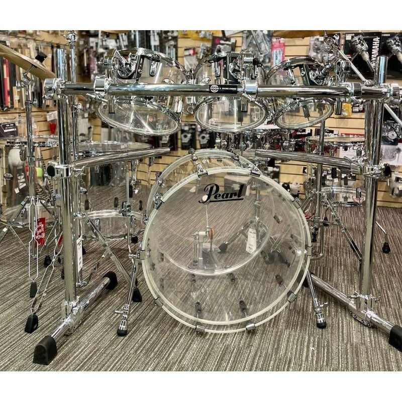 A complete Pearl drum set with a chrome finish, including a bass drum, snare drum, and a set of toms displayed on a retail floor.